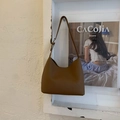 Detailed macro view of caramel brown lychee texture leather on a stylish bucket bag - Brown