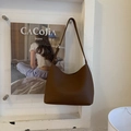 Close-up of the vintage brown semi-circle bucket bag with elegant lychee pattern leather - Brown