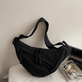 Close-up of black quilted dumpling bag with dual metal zippers and wide nylon shoulder strap - Small / Black