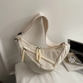 Detail view of an off-white crescent crossbody bag with woven zipper pull and wide strap - Small / Off White