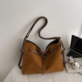 Detail einer braunen Hobo-Tasche mit Ledertextur, Nähten und Metallschnallen - Braun