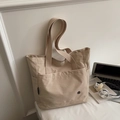 Minimalistische beige Canvas-Einkaufstasche mit Vordertasche und verstärkten Griffen - Cremeweiß