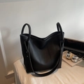 Detalle del bolso tote de cuero negro con textura litchi y asas redondas de metal fino - Negro