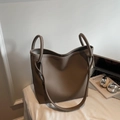 Detalle del bolso tote en cuero color topo con asas de anillo y correa ancha - Gris