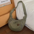 Dettaglio di borsa a tracolla in tela verde scuro con inserti in pelle e tasche a zip - Verde