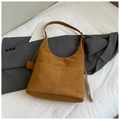 Detailed close-up of brown suede shoulder bag with white contrast stitching and twin front pockets - Brown