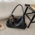 Detail of black faux leather tote bag featuring a leopard print bear charm and logo - Black with Pendant