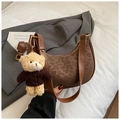 Detail view of crescent shoulder bag with leopard print, brown leather, and bear charm - With Charm / Brown