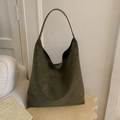 Close-up of matte olive green Hobo bag with minimalist logo in a modern interior setting - Green