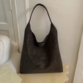 Close-up of golden logo on dark brown suede large hobo bag in aesthetic indoor setting - Brown