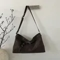 Primer plano de bolso tote de ante marrón oscuro con hebilla decorativa y textura retro - Marrón