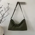 Detalle de bolso de hombro verde oliva en gamuza con ojales metálicos y correa con hebilla - Verde