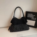 Detail der eleganten schwarz-weißen Polka-Dot-Tasche mit künstlerischer Bestickung - Schwarz
