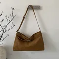 Primer plano del bolso de hombro en ante marrón con hebilla y textura mate - Marrón