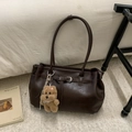 Detailed view of deep brown tote bag with metal buckle and plush puppy charm - Coffee with Pendant