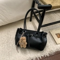 Detail of vintage black tote bag with cute teddy bear charm on plush carpet background - Black with Pendant