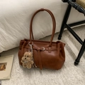 Detail of a brown PU leather tote bag with metallic buckle and cute plush dog charm - Brown with Pendant
