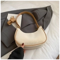 Detail of cream crescent bag with brown trim and adjustable shoulder straps - No Pendant / Off White