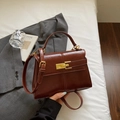 Chic dark brown faux leather crossbody bag with golden clasp in a stylish office setting - Brown No Pendant