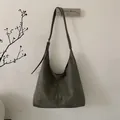 Λεπτομέρεια από σκούρα λαδί σουέτ τσάντα hobo με ενισχυμένες ραφές και ρυθμιζόμενο λουρί - Πράσινο