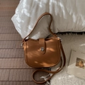 Caramel lychee grain leather bucket bag with silver buckle on a cozy white rug - Yellow Brown