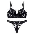 Detailoverzicht van zwarte kanten lingerieset met bloemmotieven en transparant mesh - S / Zwart