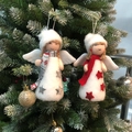 Zwei Plüsch-Weihnachtsengel-Anhänger mit Stern-Details hängend an einem Weihnachtsbaum - Engelspuppen-Set (Silber + Rot)