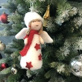 Nahaufnahme der flauschigen Weihnachtsengel-Puppe am Baum mit roten Sternen - Engelspuppe - Rot