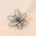 Makroaufnahme einer silbernen künstlichen Weihnachtsblume mit Glitzer und Perlenstaubbeuteln - Silber