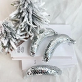 Tre banane decorative a specchio disco su libri bianchi con albero di Natale innevato - Argento