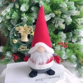 Detalle de un gnomo de Navidad con barba blanca y gorro rojo sobre libros - Gnomo Rojo de Pie