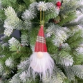Dettaglio di uno gnomo di Natale con cappello scozzese appeso a un ramo di pino innevato - Palla Babbo Natale Cappello a Righe