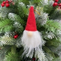 Dettaglio di uno gnomo natalizio in feltro rosso appeso a un ramo di albero di Natale - Palla Babbo Natale Cappello Rosso