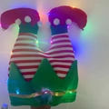 Detalle de pierna de elfo de Navidad con luces LED de colores y cascabeles dorados - Gorro Piernas de Payaso con Luz