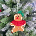Primer plano de un muñeco de jengibre de fieltro colgado en un árbol de Navidad - Adorno Hombre de Jengibre Femenino