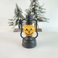 Close-up of Halloween pumpkin lantern keychain with orange LED face and black frame - Pumpkin