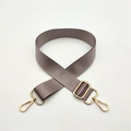 Close-up of adjustable taupe nylon bag strap with polished gold lobster clasps and buckle - Light Purple