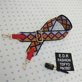 Close-up of ethnic geometric patterned wide strap with red leather ends and gold metal clips - Style 2 Red