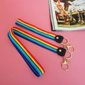 Regenbogen-Schlüsselband mit goldenem Ring und Karabinerhaken auf rosa Hintergrund - Schwarzes Leder Set Lang Und Kurz
