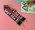 Close-up of woven wide bag strap featuring colorful ethnic patterns and gold metal buckles - Alphabet