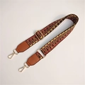 Close-up of ethnic geometric woven bag strap with leather ends and golden metal hardware - Dark with Brown