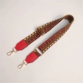 Close-up of colorful woven geometric bag strap with red leather and gold metal hooks - Dark with Red