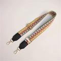 Détail d'une bandoulière tissée colorée avec motifs géométriques et crochets dorés - Noir Tissé Clair