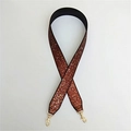 Macro shot of glittery bronze red wide replacement bag strap with golden metal buckles - Brown