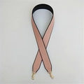 Dettaglio di un'ampia tracolla in pelle PU rosa e nera con ganci in metallo dorato - Rosa