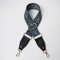 Dettaglio della tracolla intrecciata blu geometrica con ganci dorati e finiture in pelle - Quadretti Blu