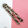 Macro detail of faux leopard fur bag strap with gold metal hooks on dual-tone background - Beige Leopard