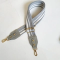 Detailaufnahme der gestreiften Baumwoll-Taschengurt mit Goldhaken und Lederverstärkung - Grau + Graues Leder + Goldener Haken