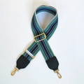 Détail d'une bandoulière large tissée à motif géométrique bleu et vert avec boucles dorées - Sangle Bleue + Noir