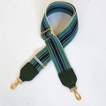 Close-up of geometric embroidered bag strap with golden metal lobster clasps and green leather - Blue + Green Leather